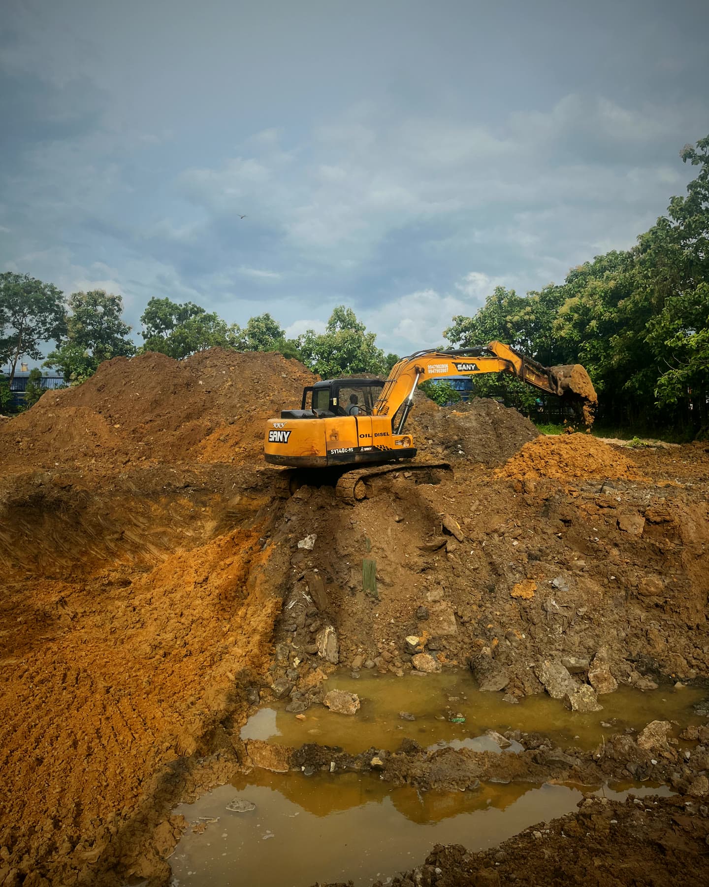 Trinox HQ — the excavation opened under monsoon cloud